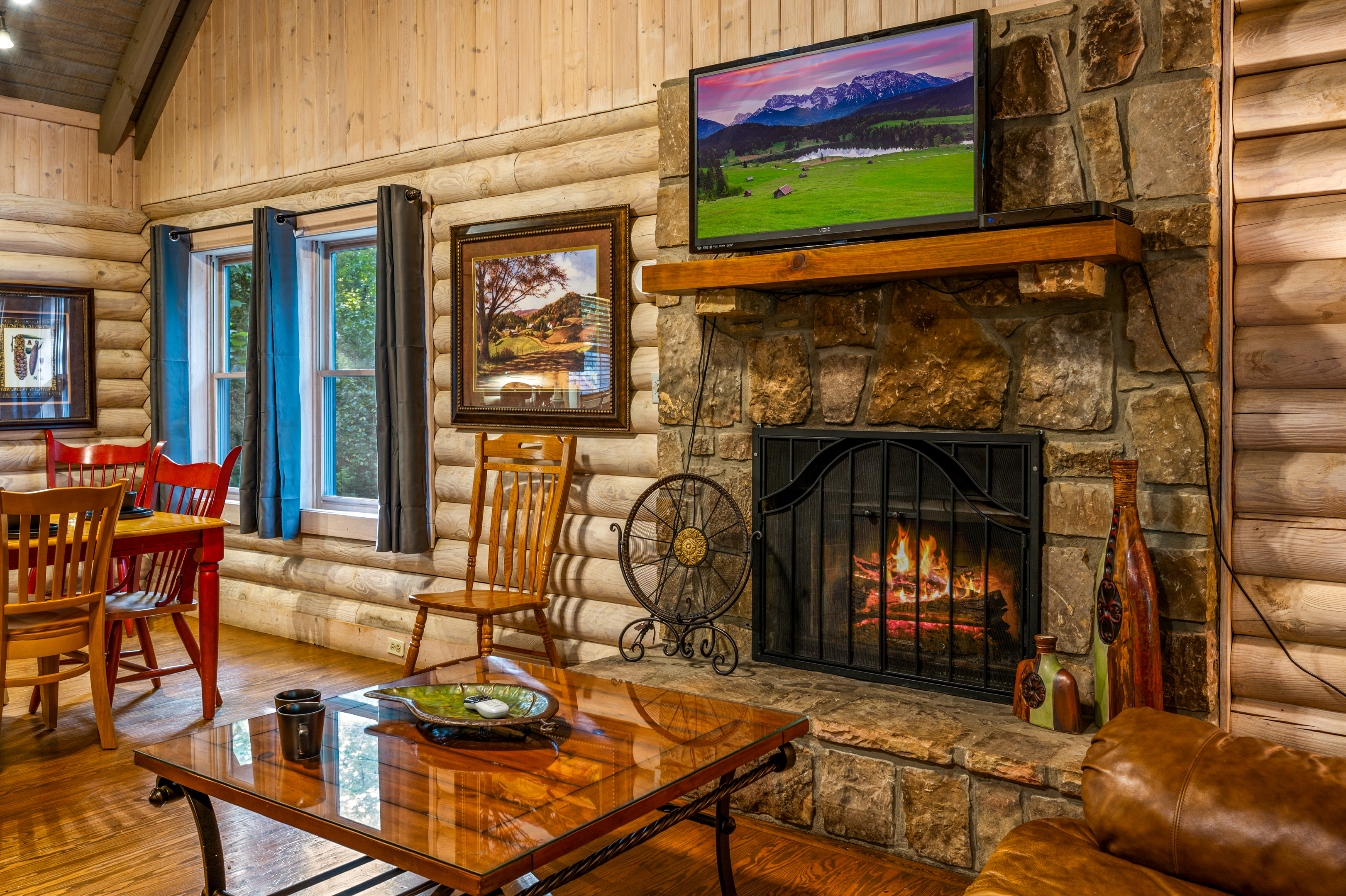 Cozy mountain cabin living room with warm fireplace & flat-screen TV.