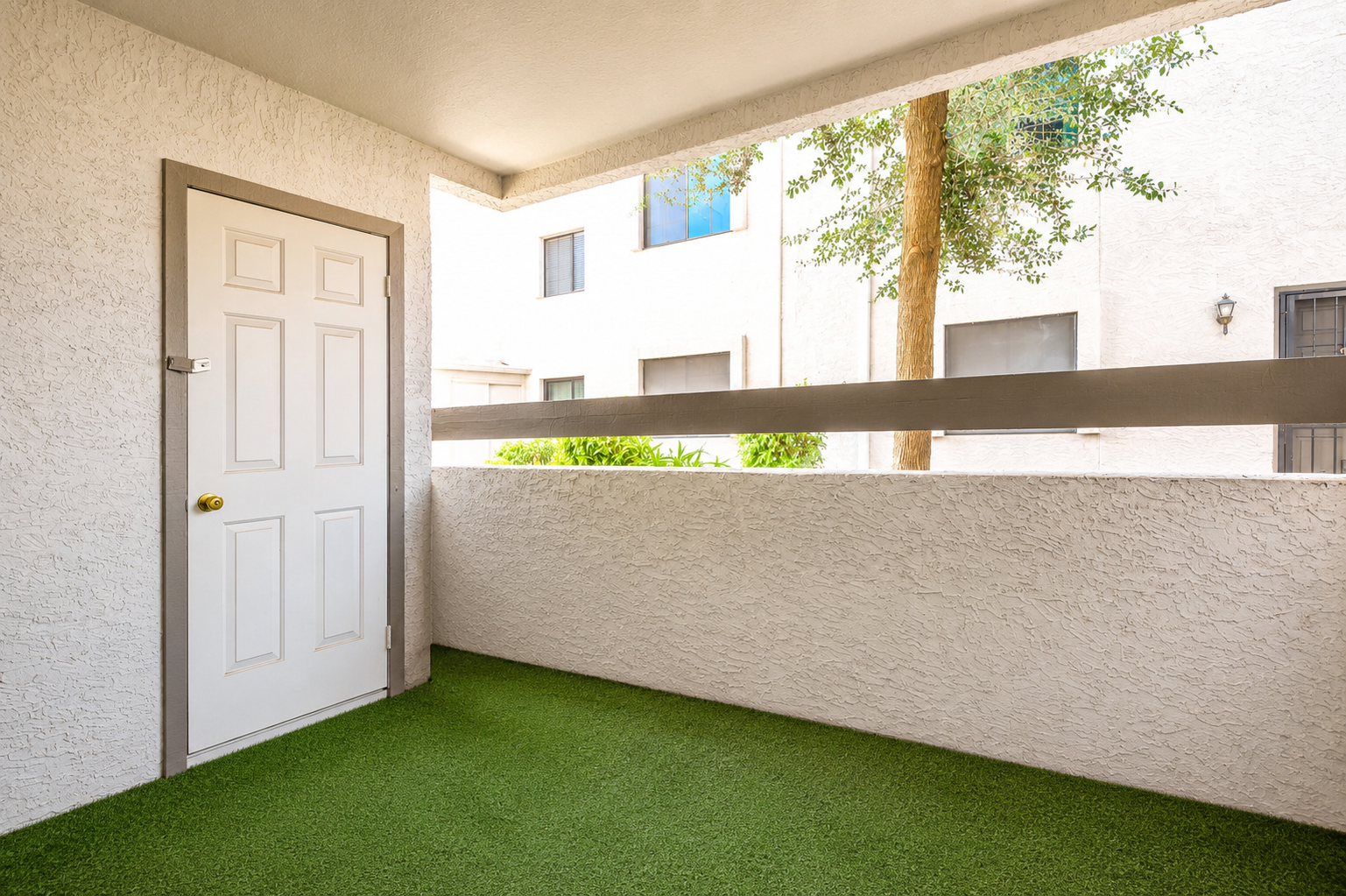 Private covered patio with turf flooring, storage closet, and sliding door access back into the living room and kitchen.
