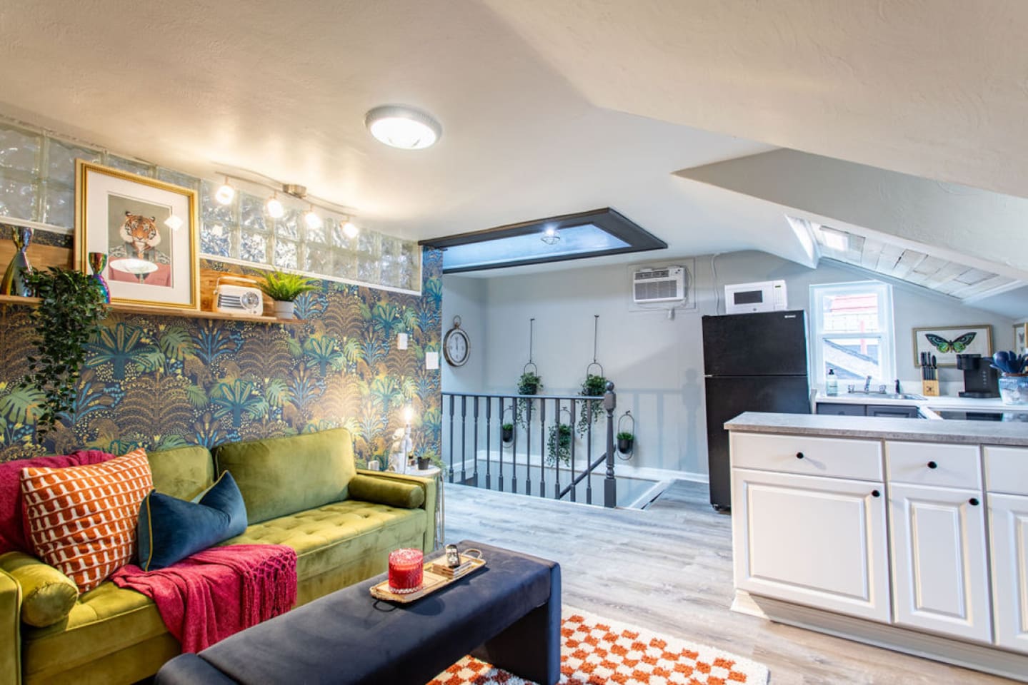 Ascend the inviting staircase to your cozy home away from home. The steps lead into a bright and airy living space, beautifully illuminated by natural light from the skylight. This thoughtfully designed apartment blends essential amenities with styli