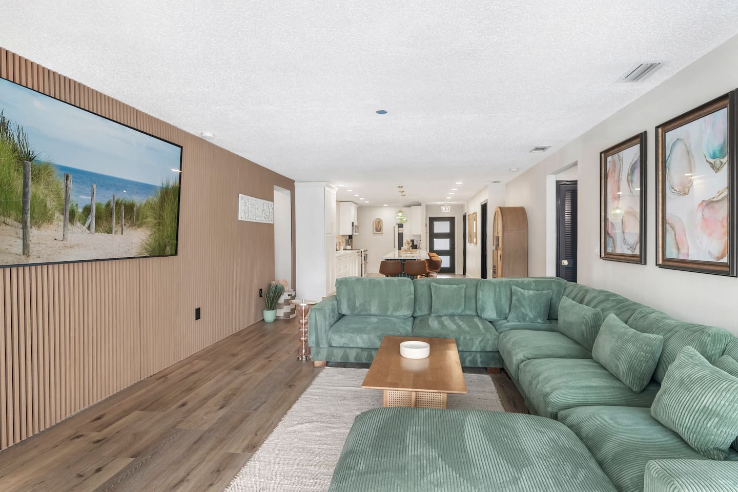 Stylish Living Room with 85-Inch TV. Acoustical accent wall, open to the kitchen and the pool 