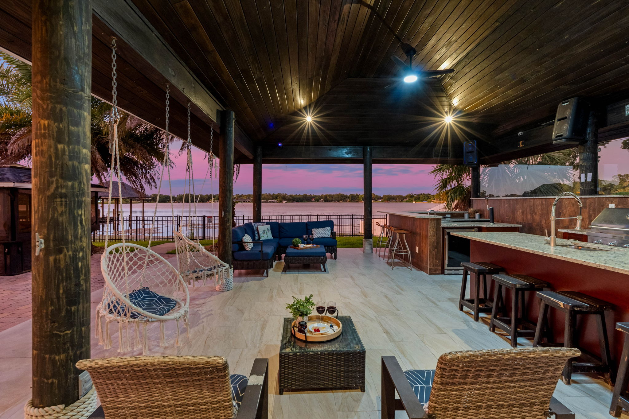Swing gently in hammock chairs or sip wine on plush outdoor couches as the pink and purple sky reflects off the water.