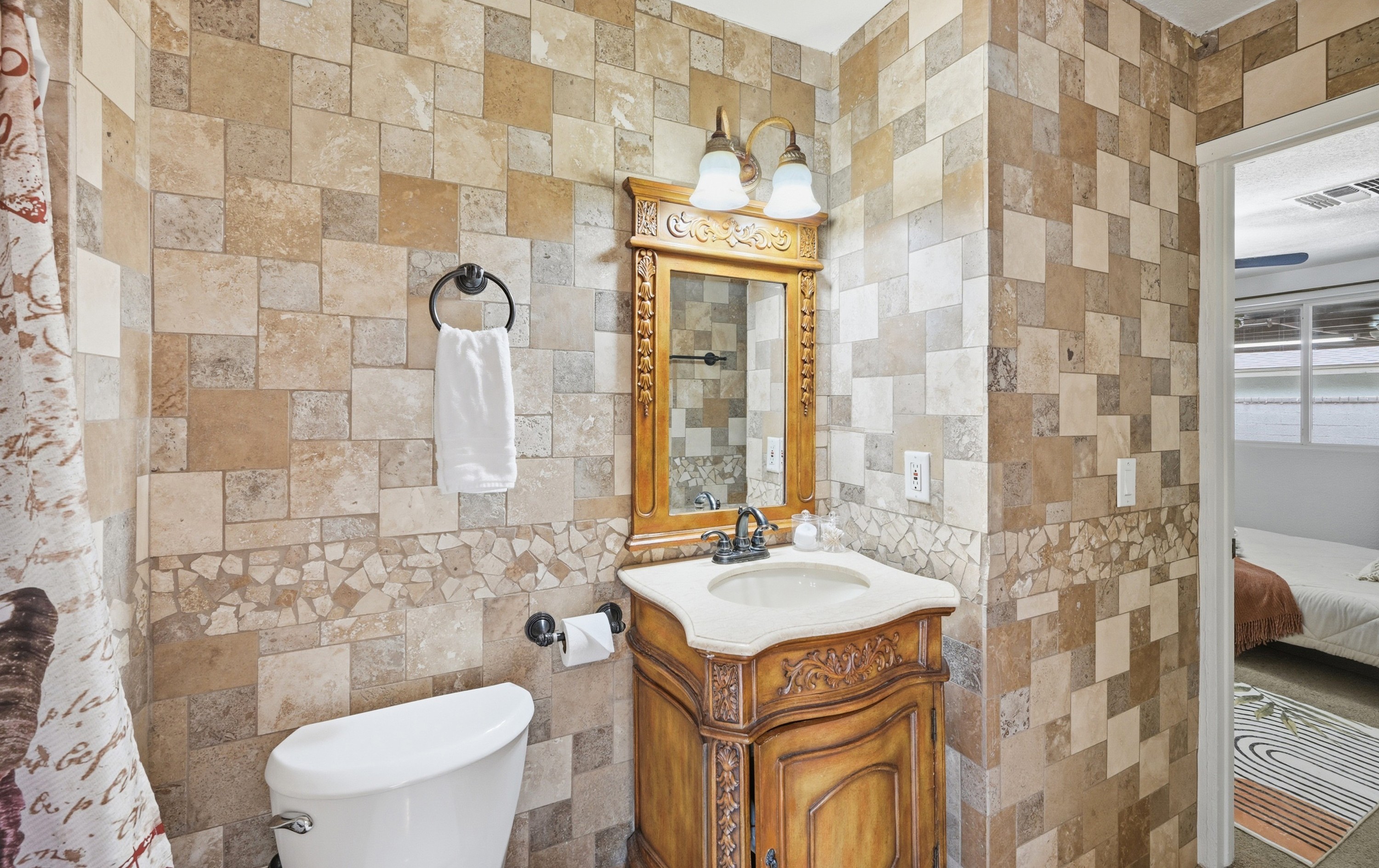 Refresh in this beautifully tiled walk-in shower with elegant stonework and serene garden views just steps away.
