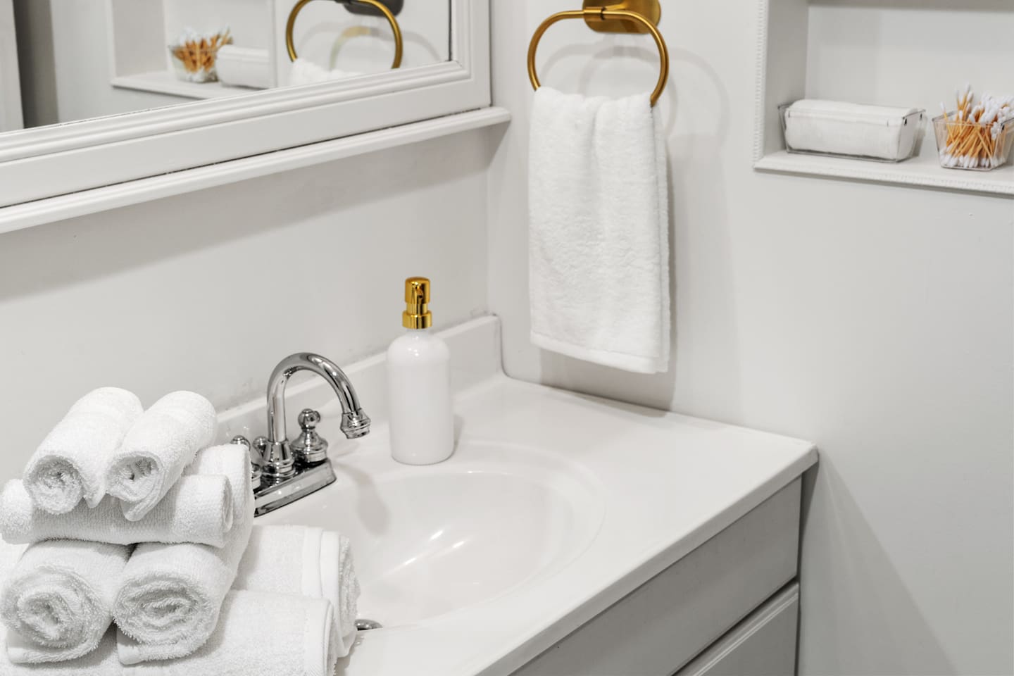 Sparkling clean vanity with fresh towels, gold accents, and thoughtful toiletries—your spa-like bathroom retreat starts here.