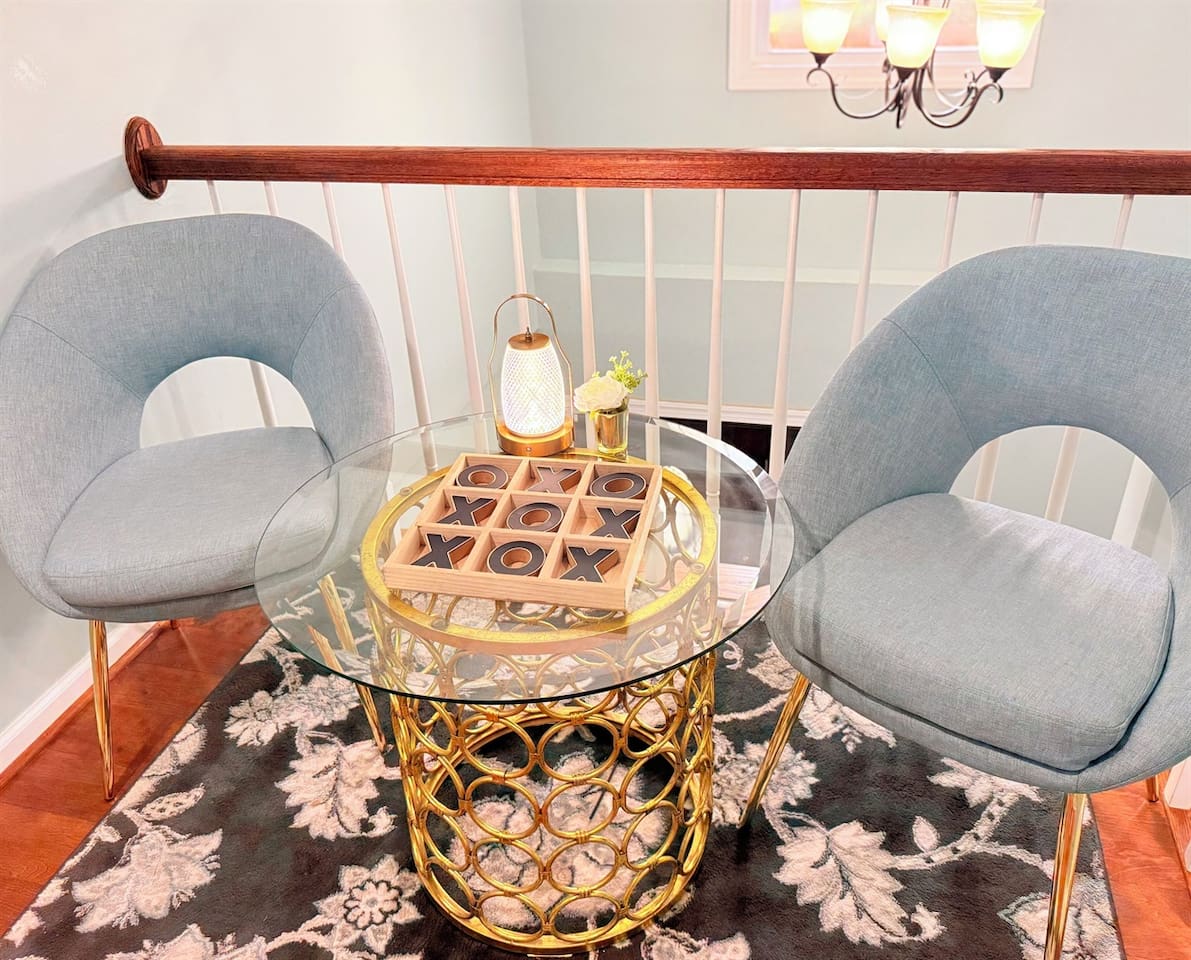 Conversation-ready lounge nook with modern chairs, accent rug, and warm gold decor. 