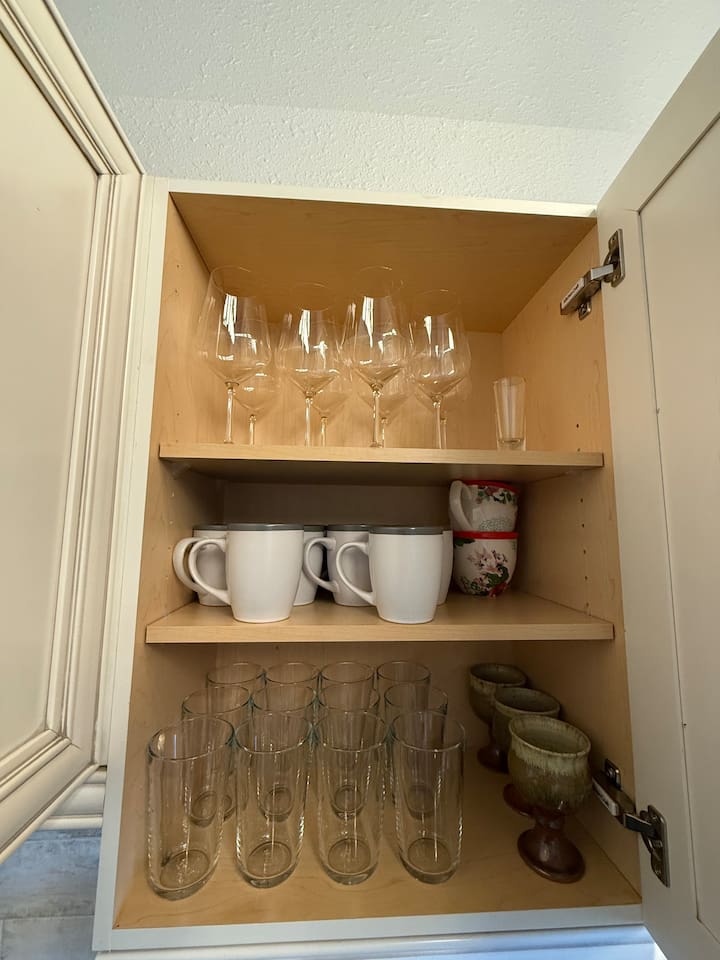 Mugs & Glasses: A close-up view of the stocked glassware and coffee mugs, highlighting the ample supply for all guests.