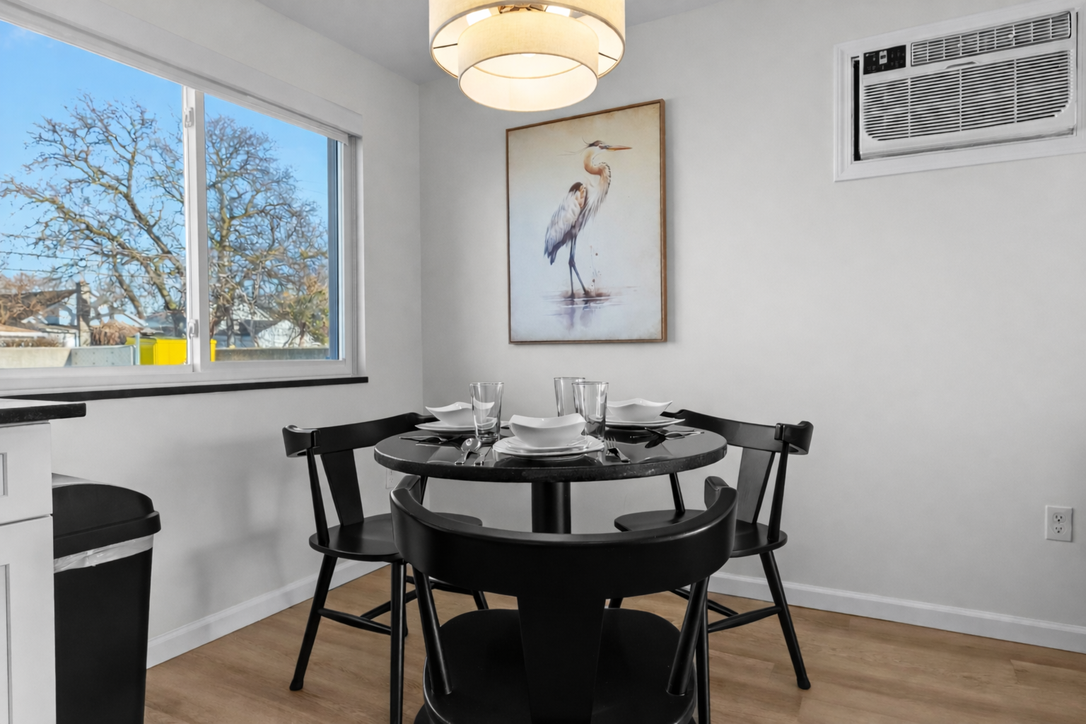Modern dining area with stylish lighting, seating for four, and natural light—perfect for relaxed meals, morning coffee, or casual evenings together.