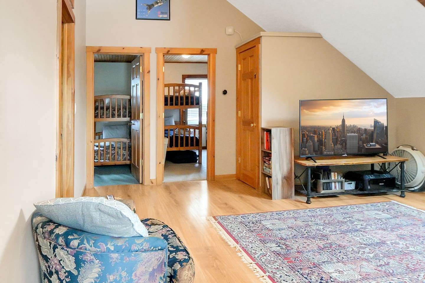 Upstairs hangout space with a TV, cozy seating, and direct access to two bunk rooms—perfect for movie nights or relaxing after a day out.