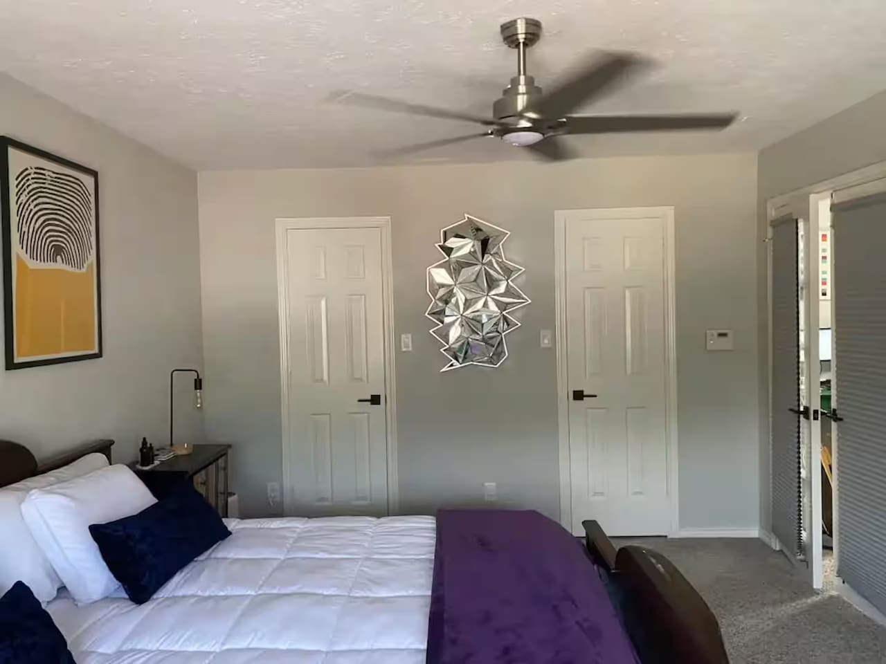 Spacious bedroom with king bed and vibrant wall art.