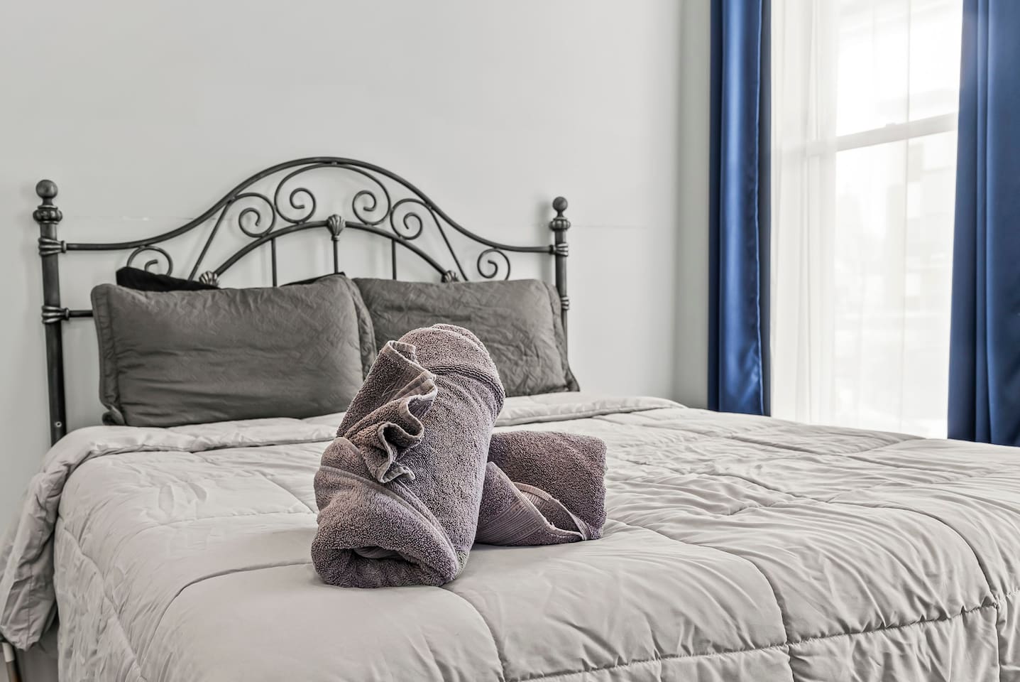 Close-up of the queen-size bed with plush pillows, fresh linens, and a welcoming hotel-style setup.
