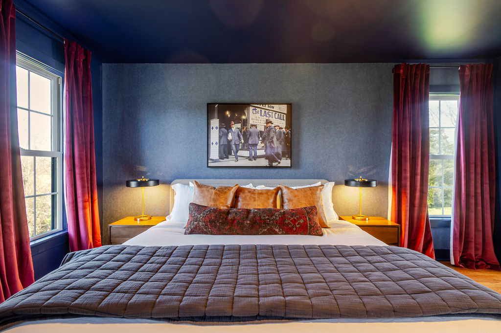 Rich navy walls, warm leather accents, and a touch of vintage charm — this upstairs king bedroom captures Kentucky’s timeless elegance, offering a restful retreat steeped in quiet character.