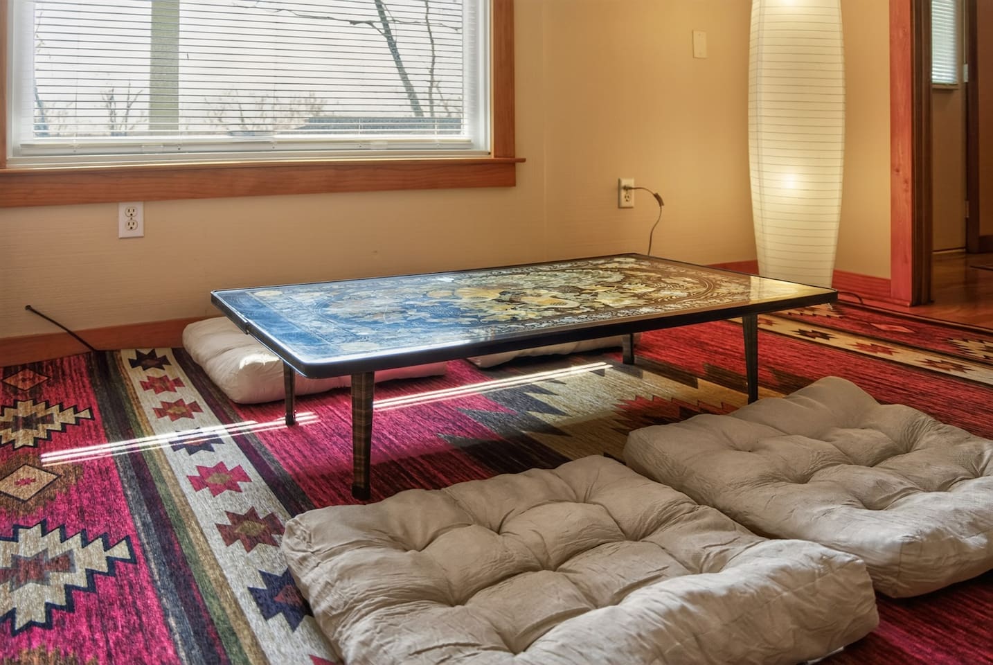 Relax in a Japanese-style living room with a low table, floor seating cushions, and warm, calming design—perfect for tea, conversation, or quiet moments, blending comfort and culture into a unique, peaceful retreat experience