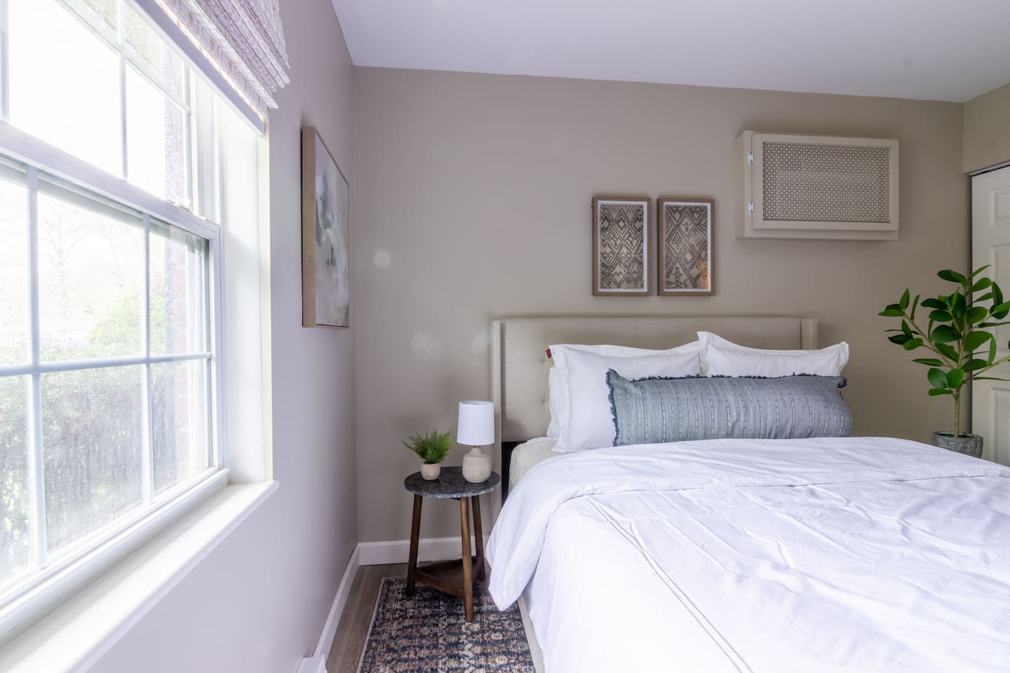 Natural light spills through the window, warming up the crisp white bedding and cozy textures.