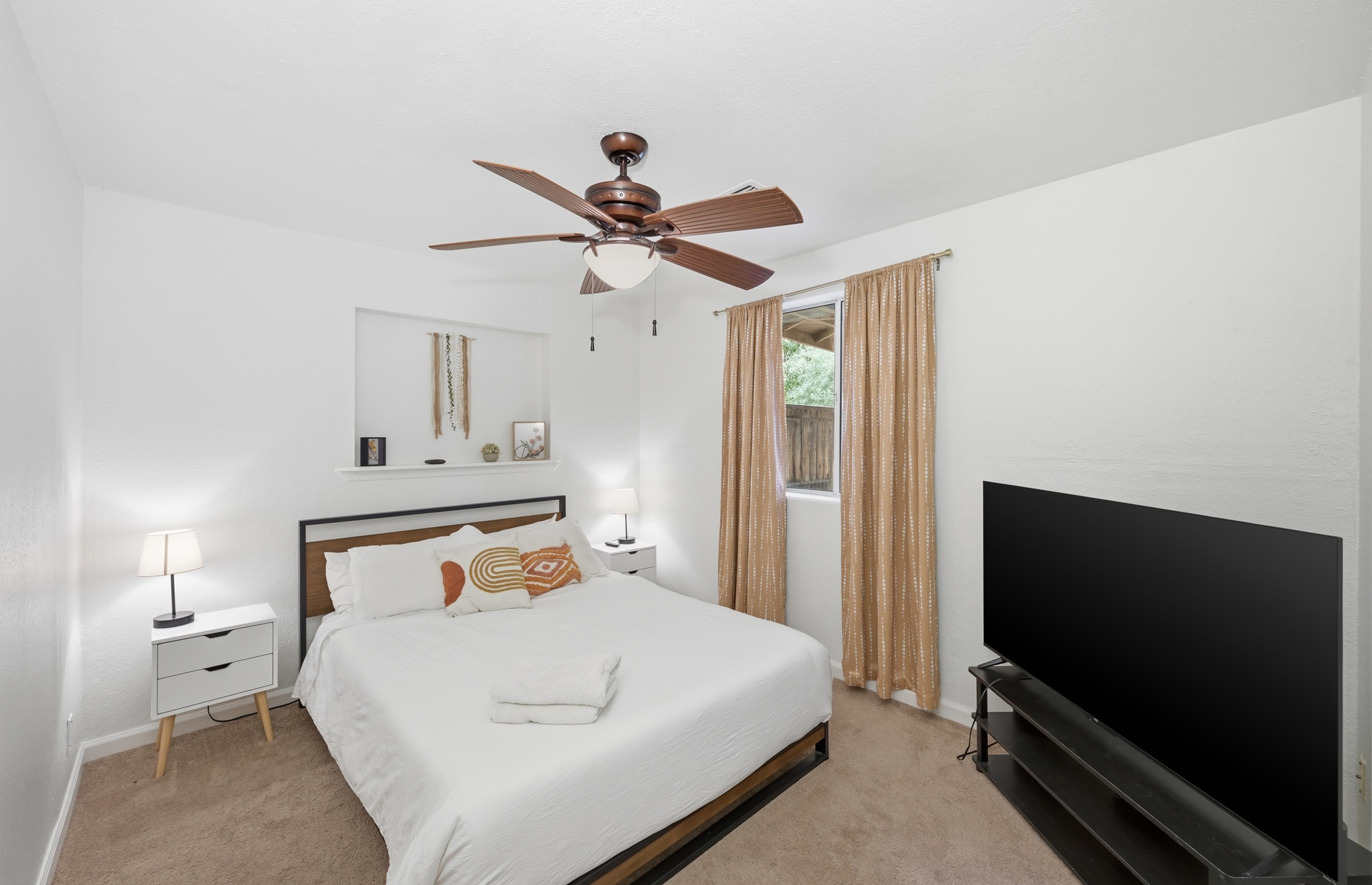 Chic and cozy, this sun-filled bedroom features soft neutrals, modern decor, and a peaceful ambiance perfect for a restful night's sleep.