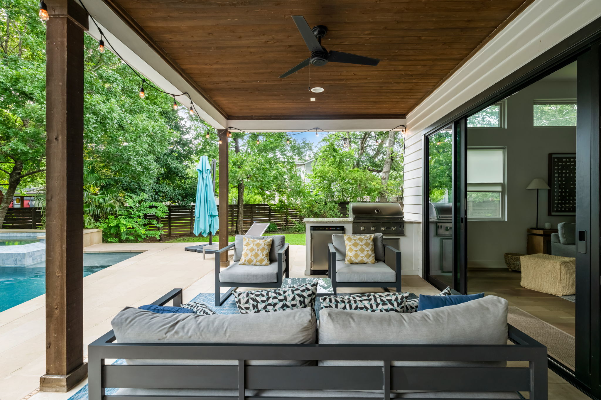 Stylish covered patio featuring modern outdoor furniture and direct pool access — an ideal spot for morning coffee or evening cocktails.