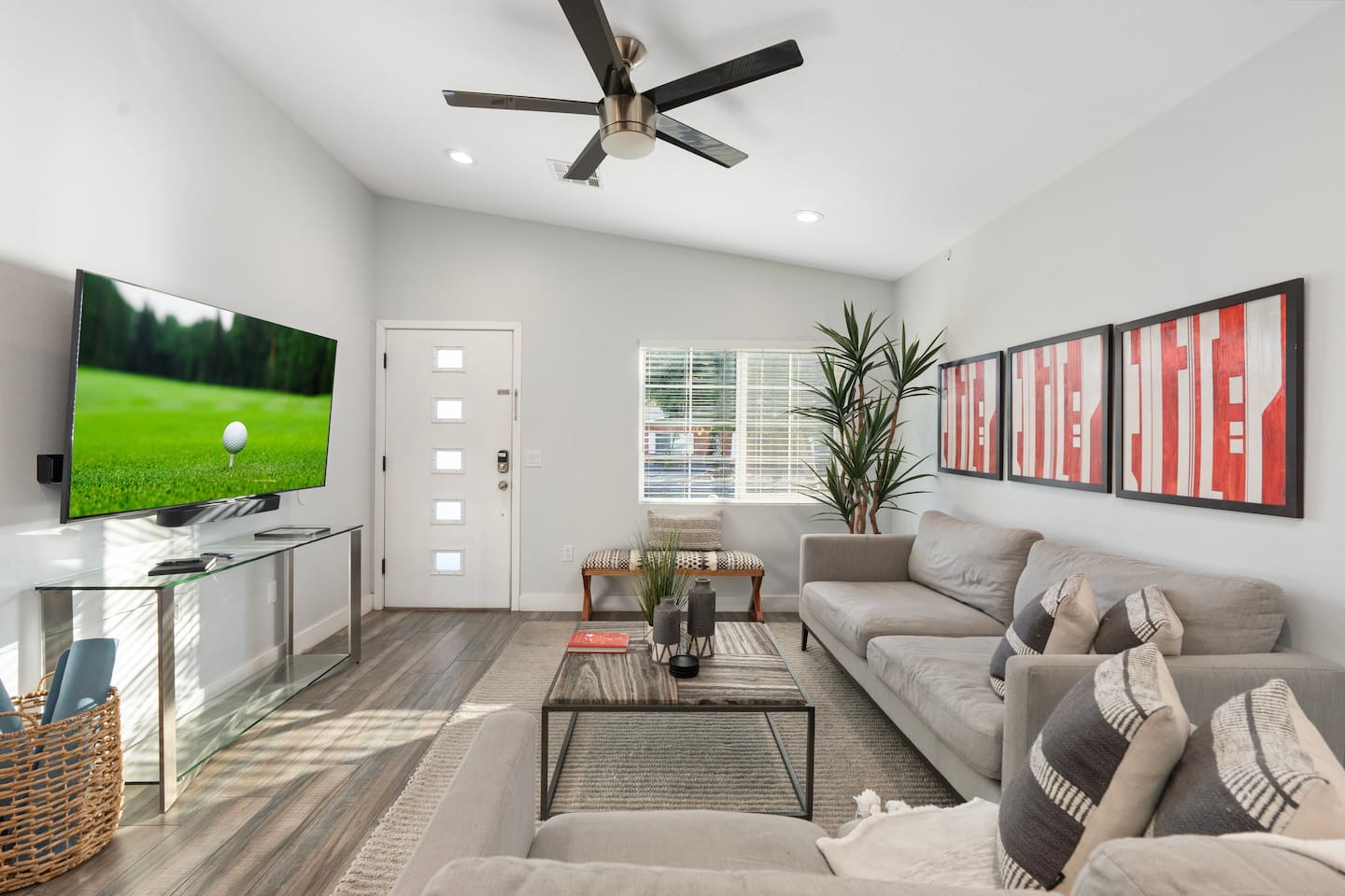 Spacious living room with soft gray sofas, chic wall art, and a stylish coffee table, perfect for relaxing or entertaining.