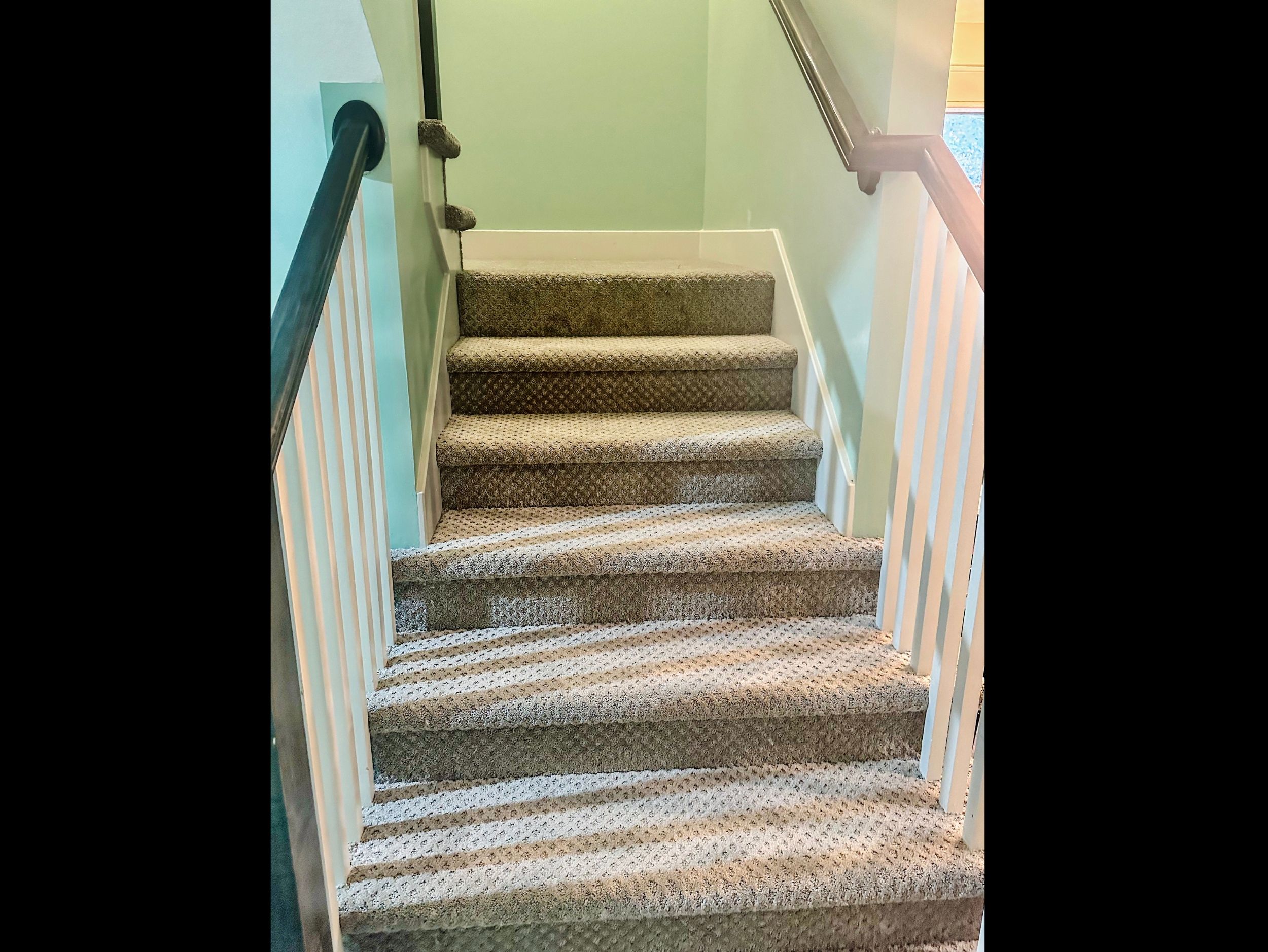 Main-level stair landing leading to the upper level bedrooms, designed for comfort and natural separation of spaces.