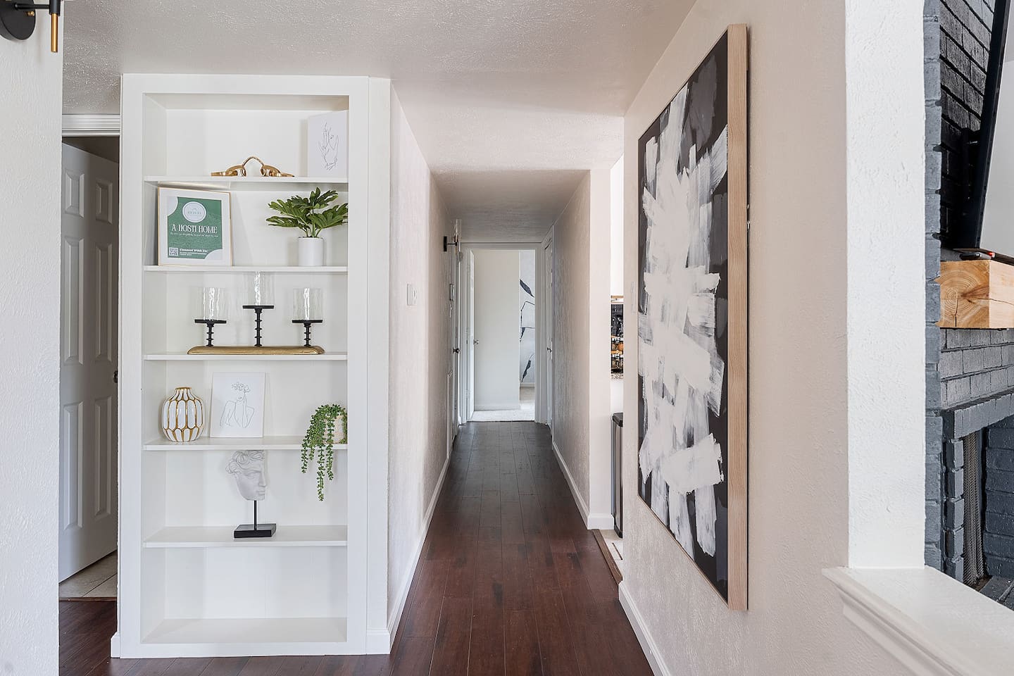 Walk down this artfully decorated corridor, featuring a stylish built-in shelf and modern artwork. The clean lines and decor enhance the inviting atmosphere.