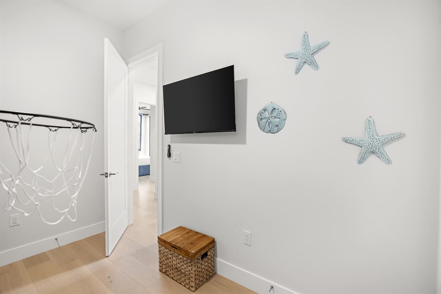 This cozy room features light blue beach decor on the walls, creating a relaxing vibe, with a TV for guests staying in the bunk bed to enjoy while unwinding.