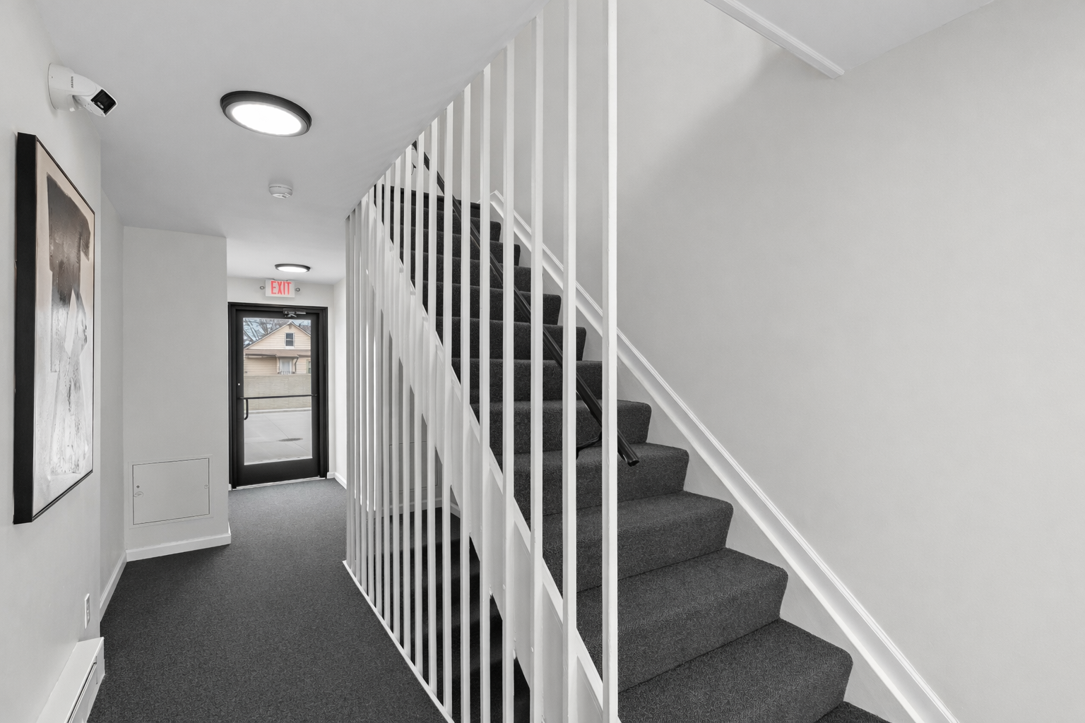 Bright, secure common stairwell with clean finishes and modern lighting—easy access to the unit in a well-maintained shared space.