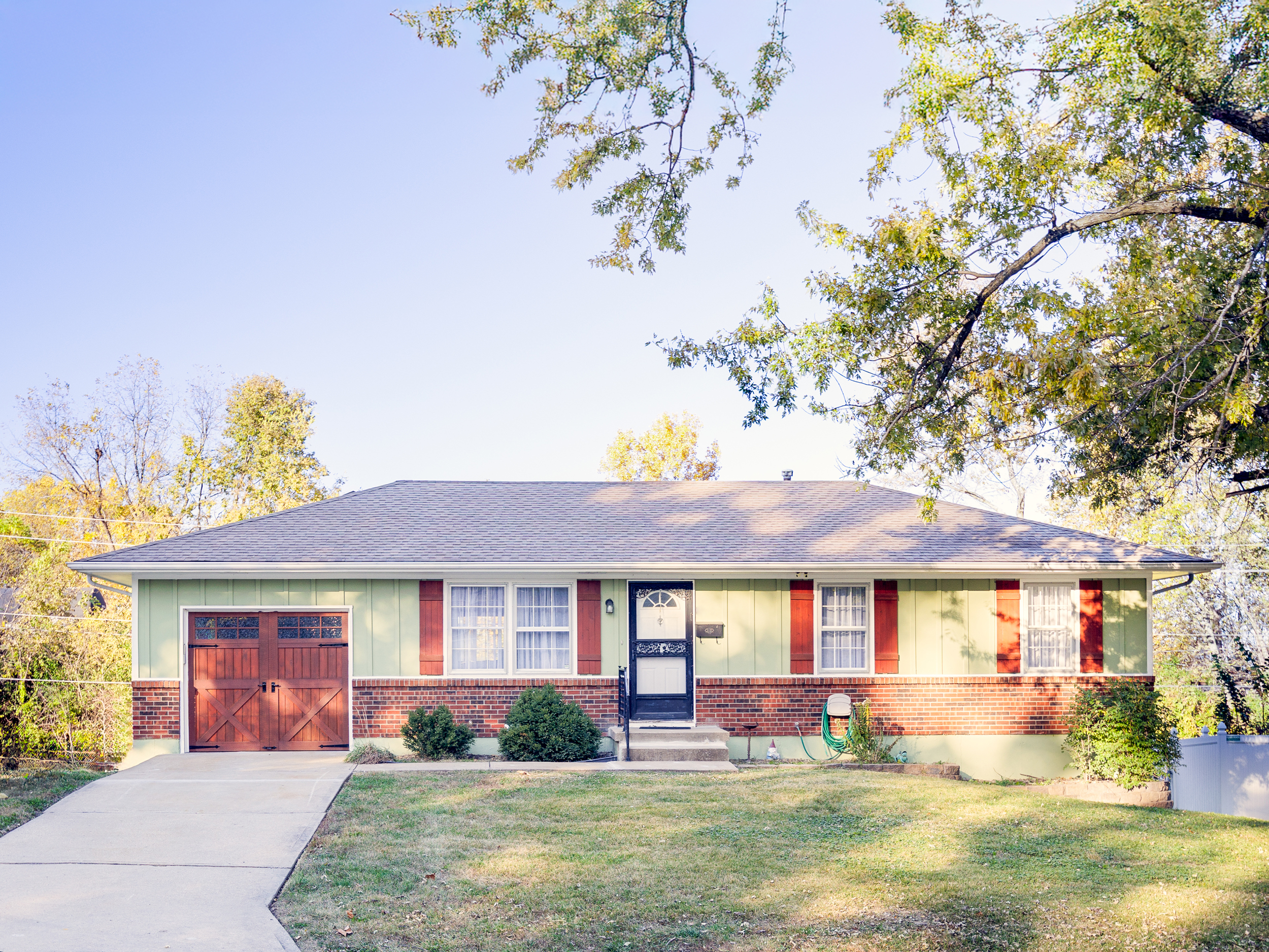 Charming street-front view with mature trees and easy curb access, offering a welcoming first impression.