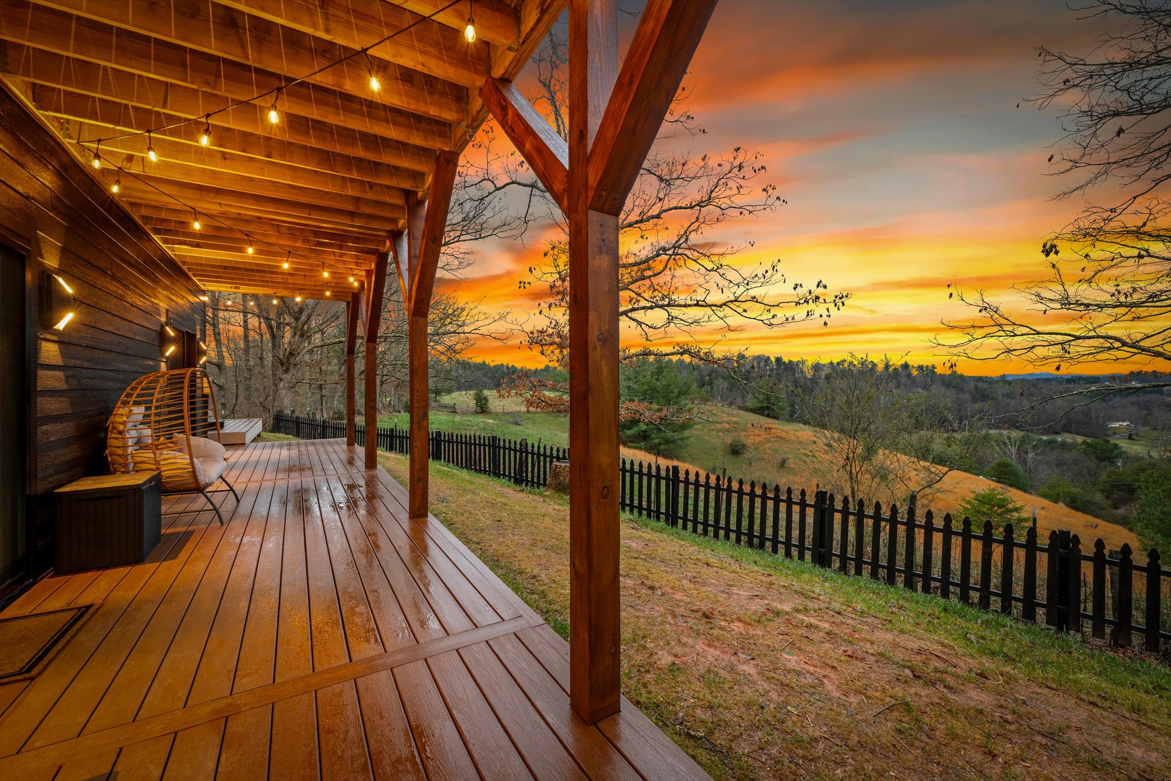 {Deck Views} Covered lower deck with mountain views, string lighting, and seating — a perfect spot for morning coffee or sunset drinks.
