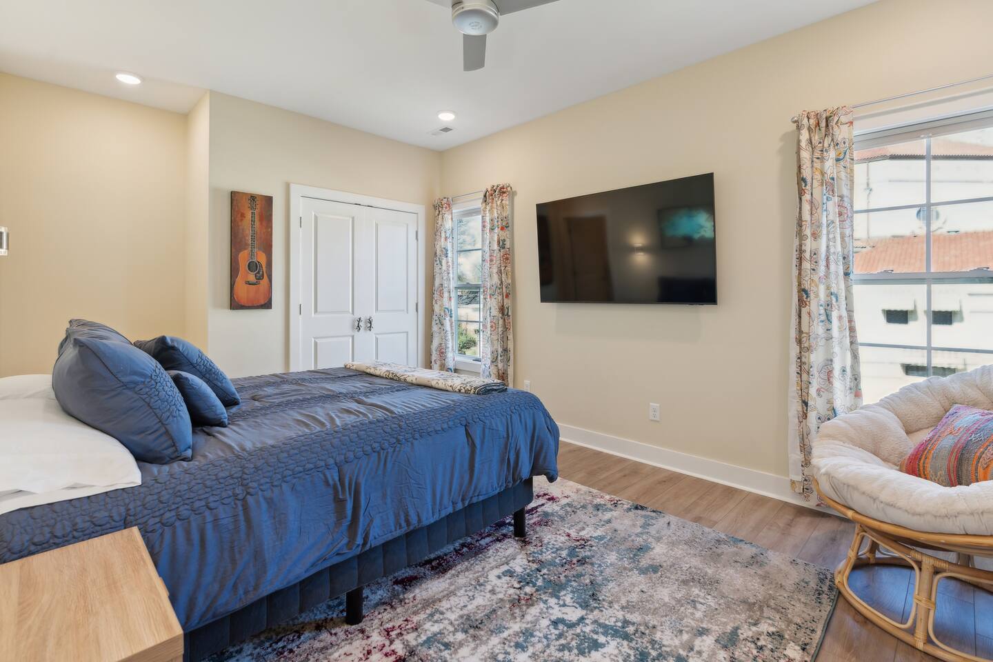 Primary bedroom w/ensuite full bathroom. 65 in TV, closet, dresser and papasan chair. Black out blinds to help ensure a restful night!
