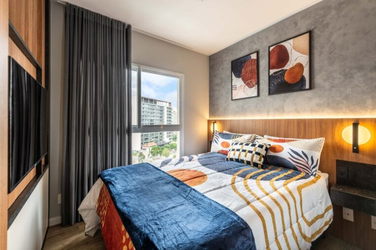 Janela com vista urbana e cama queen confortável Quarto iluminado naturalmente com vista, ar-condicionado e estilo moderno. Ideal para relaxar com conforto.