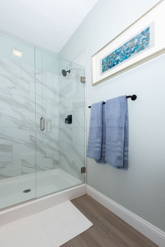 Primary bathroom shower and toilet seperate from sink and dressing area.
