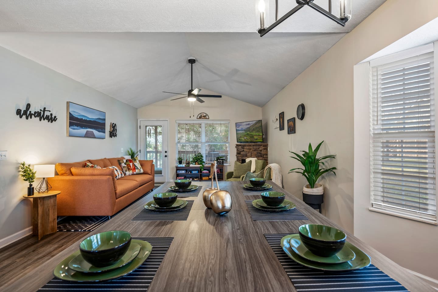 Bright and stylish open-concept space with vaulted ceilings, cozy seating, and a modern dining area set for six. Perfect for relaxing or entertaining.