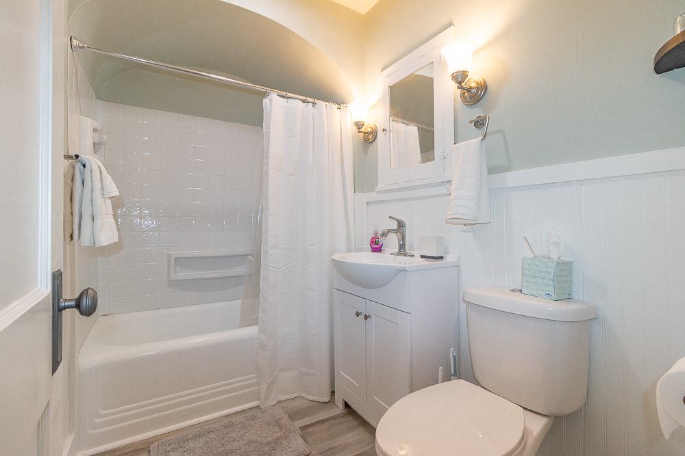 Fresh, clean bathroom with a tub/shower combo and fresh towels provided.