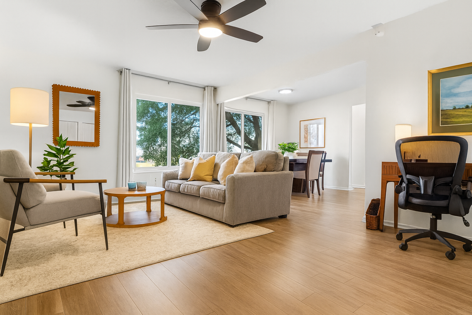 Inviting and open main living space with ceiling fan, plush seating, and plenty of natural light.