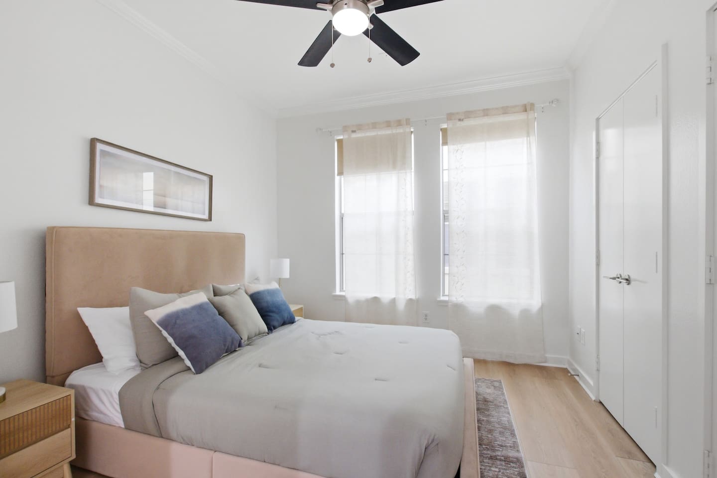 Queen bedroom with natural light, ceiling fan, and a calm, neutral palette. Steps from the rooftop deck and the primary suite, on the top floor of the townhome.

