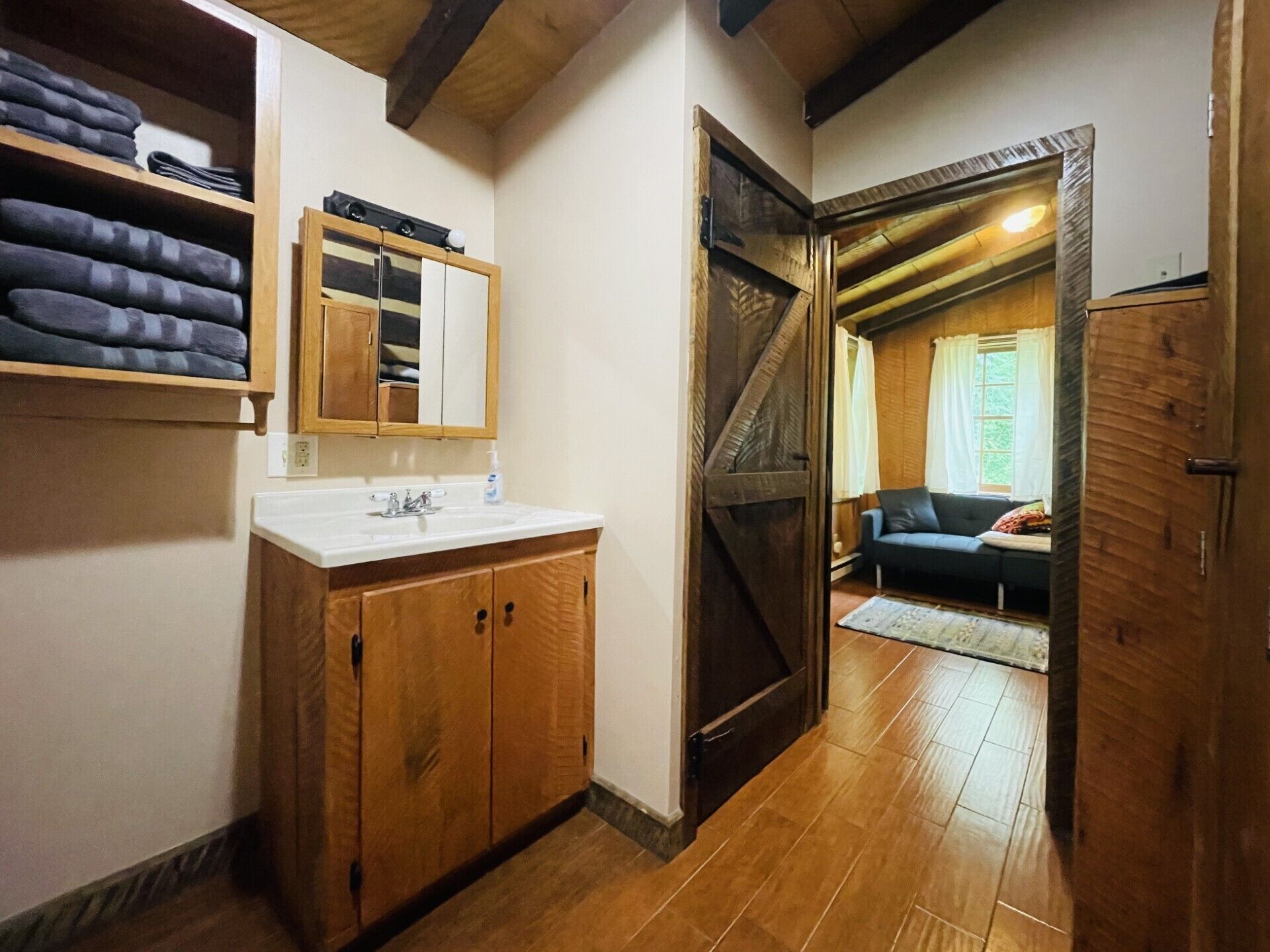 Stacking washer and dryer for guest use behind barn door.