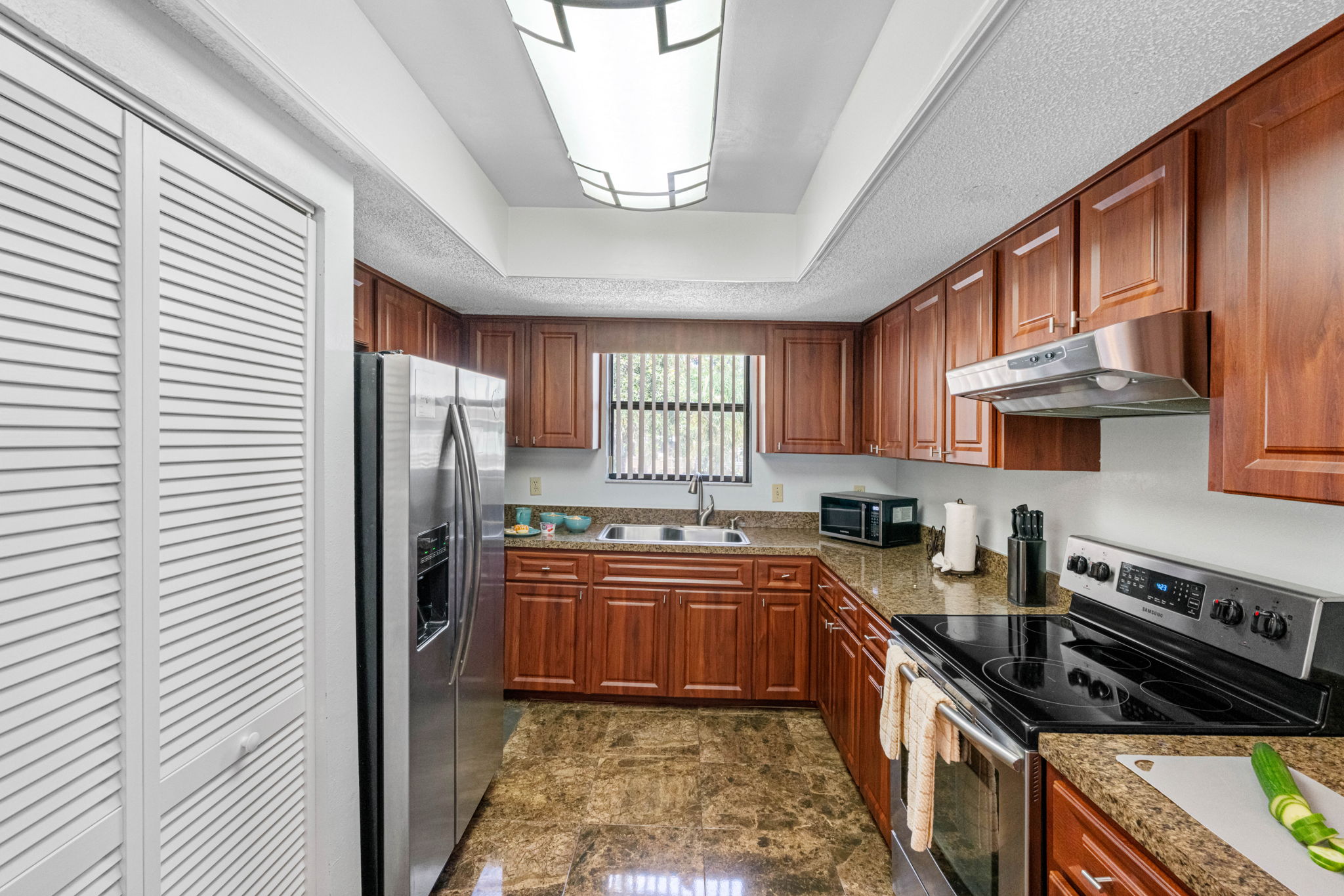Paired with the rich cabinetry and glossy marble-look tile floors, the space feels both luxurious and functional.