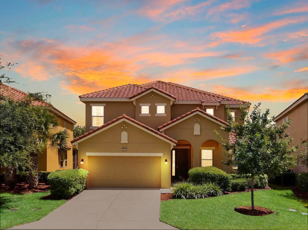 Gracie Orlando Getaway at sunset, with the front exterior and driveway illuminated.