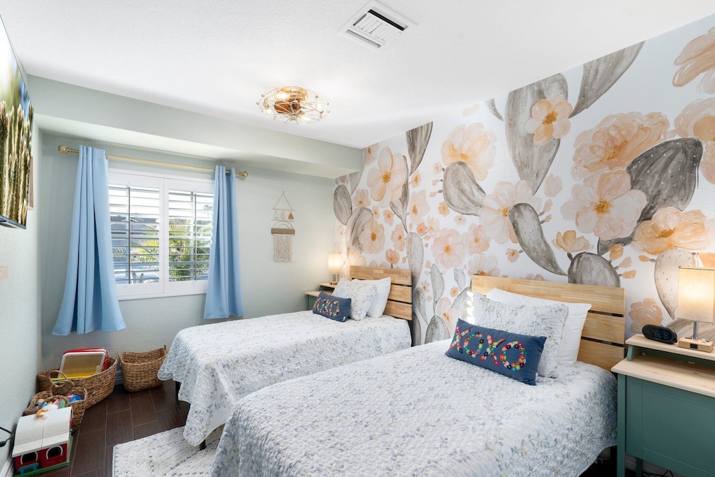 This room features two twin beds, blackout curtains and plantation shutters.