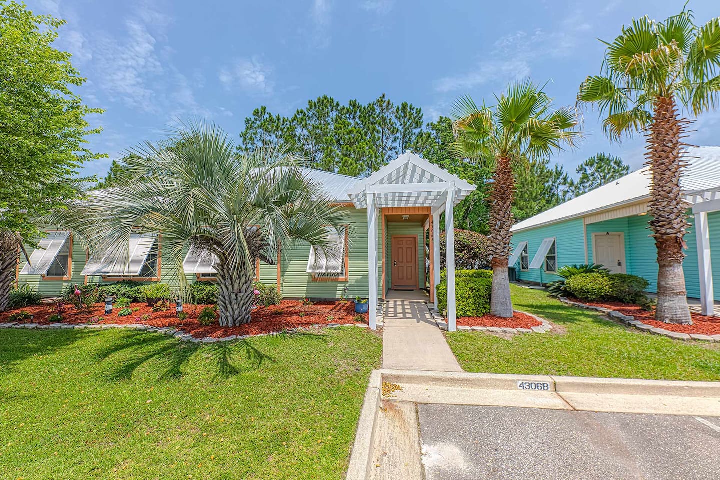 Charming Entrance: Step into paradise surrounded by vibrant greenery and tropical palm trees!