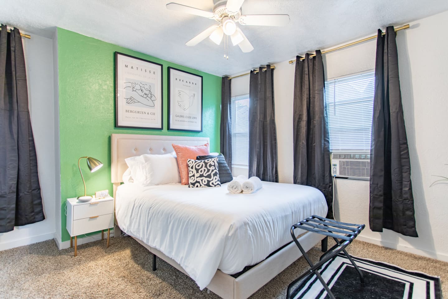 A comfortable bedroom featuring a queen-sized bed, complemented by a few windows that bring in natural light, creating a serene and inviting space.