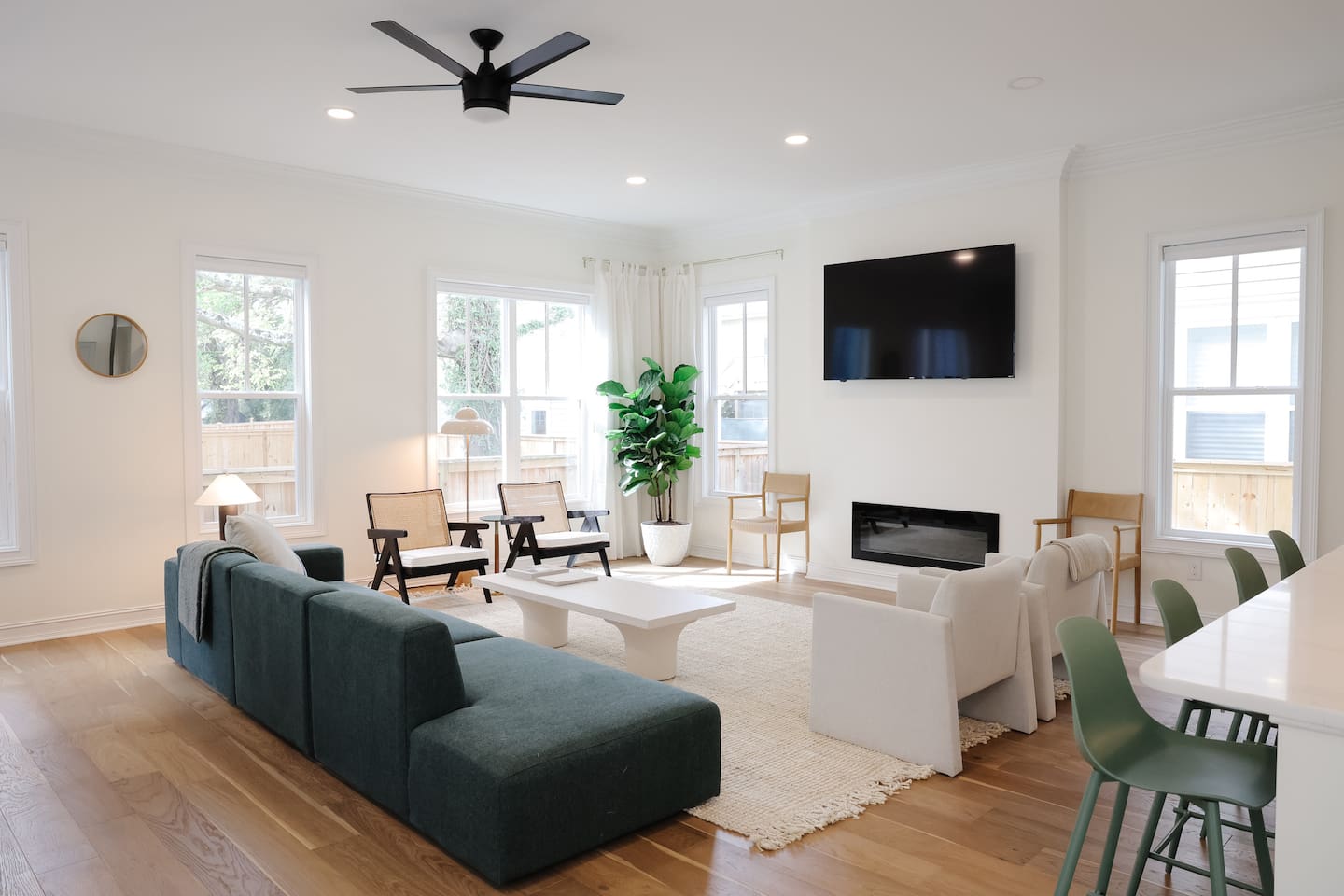 The light-filled living room features an oversized Floyd couch, a 70" smart TV and an open floor plan that flows seamlessly into the kitchen and dining areas. Great spot for hanging with a large group.
