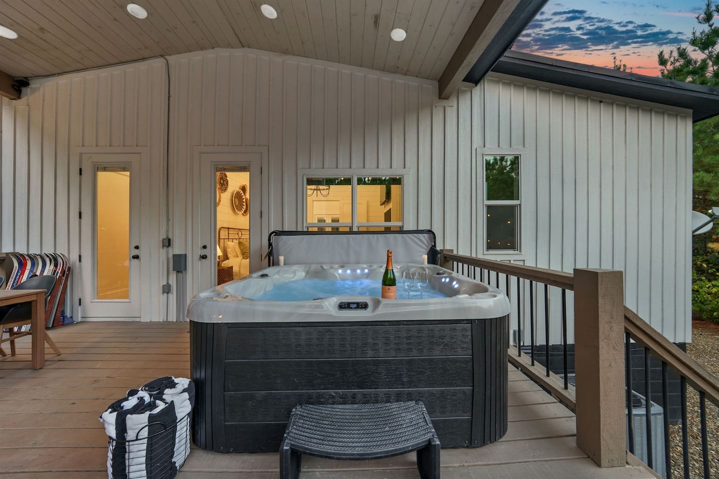 Unwind in the warm bubbles of the private hot tub, glass of wine in hand, as string lights twinkle above and the forest whispers around you—a perfect setting for romance and relaxation.