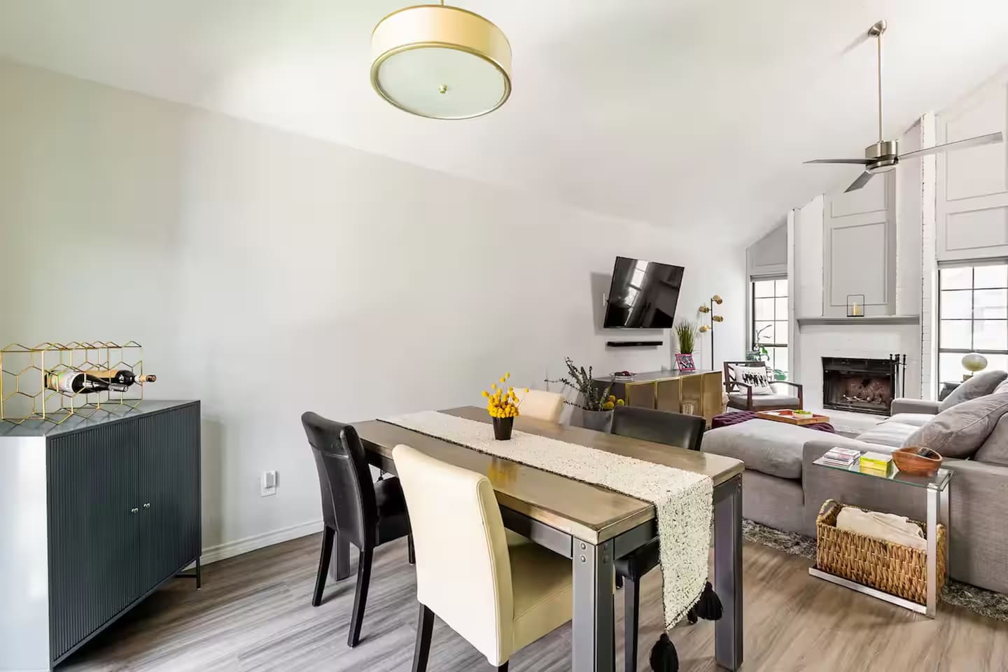 Dining room with seating for four and unique lighting fixture.