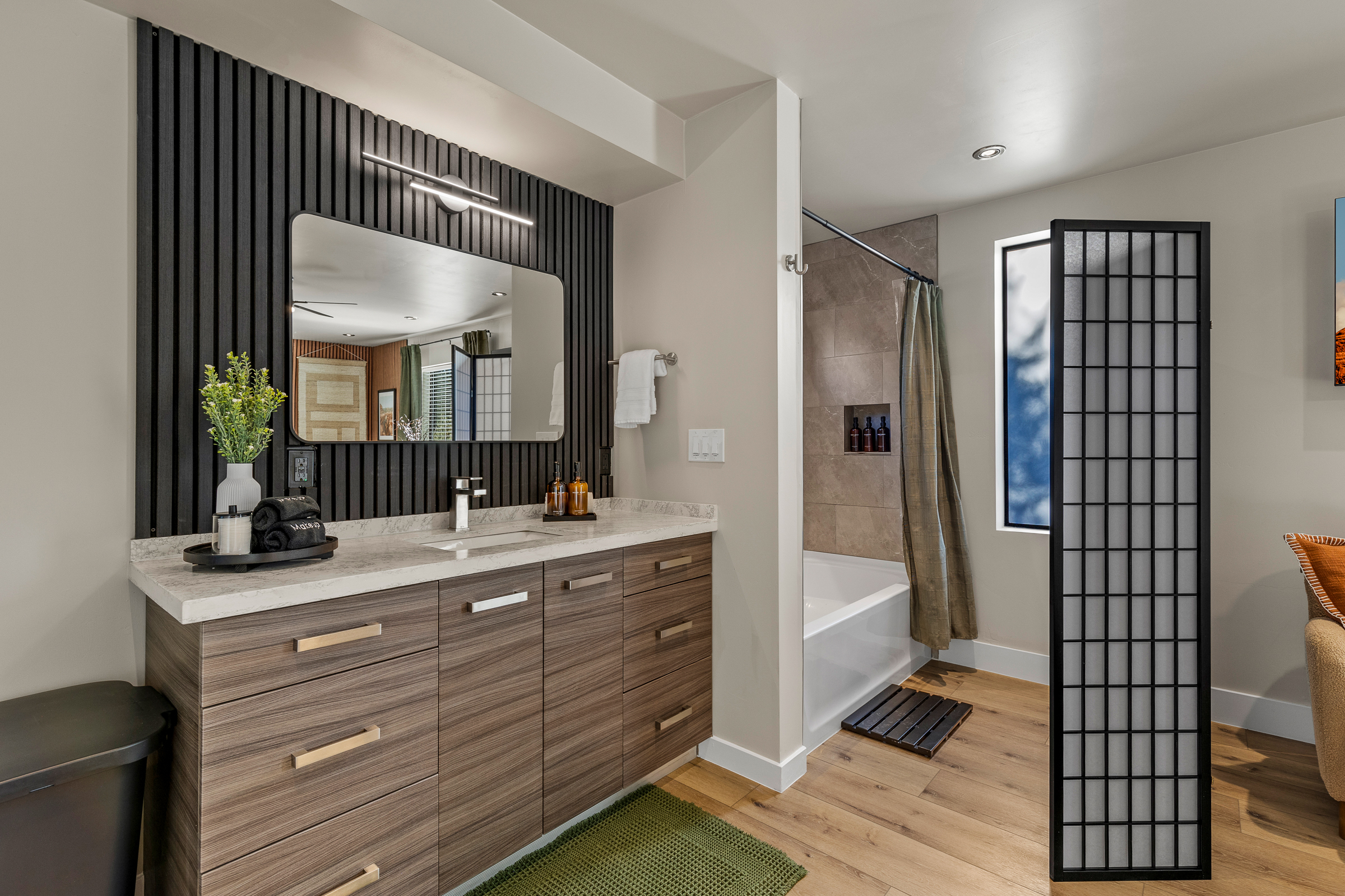 Modern ensuite bathroom at the guesthouse featuring a spacious vanity, tub/shower combo, and thoughtfully stocked essentials.