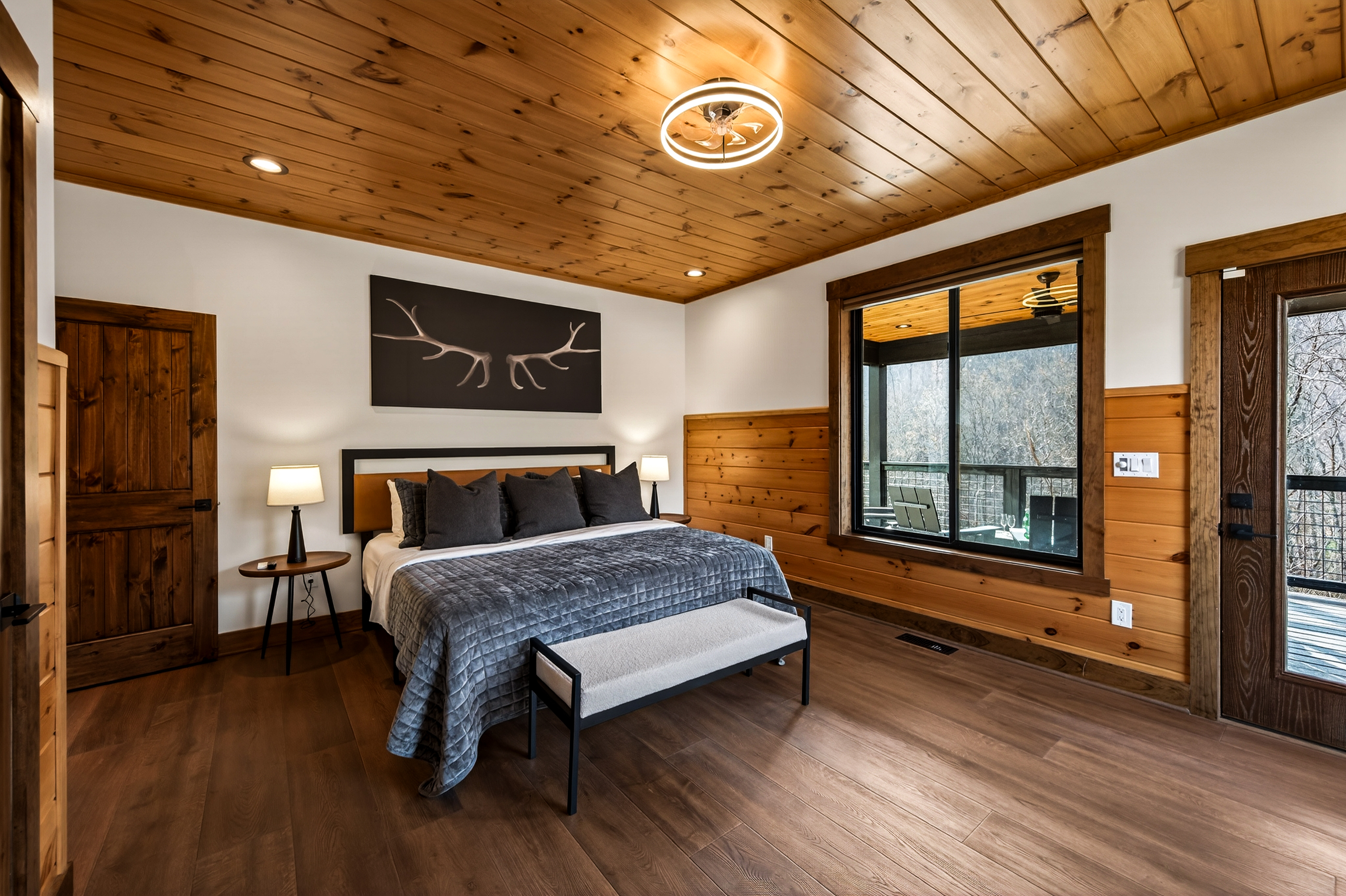 Relax in the spacious main level king bedroom with a large TV, dedicated desk & direct deck access. Unwind in the en-suite bathroom featuring a walk-in shower with a natural river rock floor, bringing  the Smoky Mountains indoors for a spa retreat.