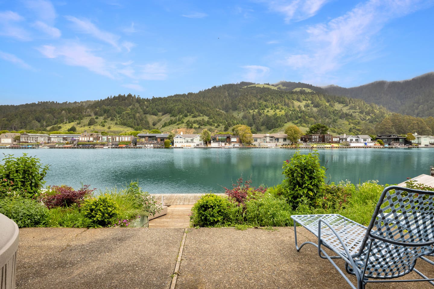 Patio seating with serene lake and mountain views.

