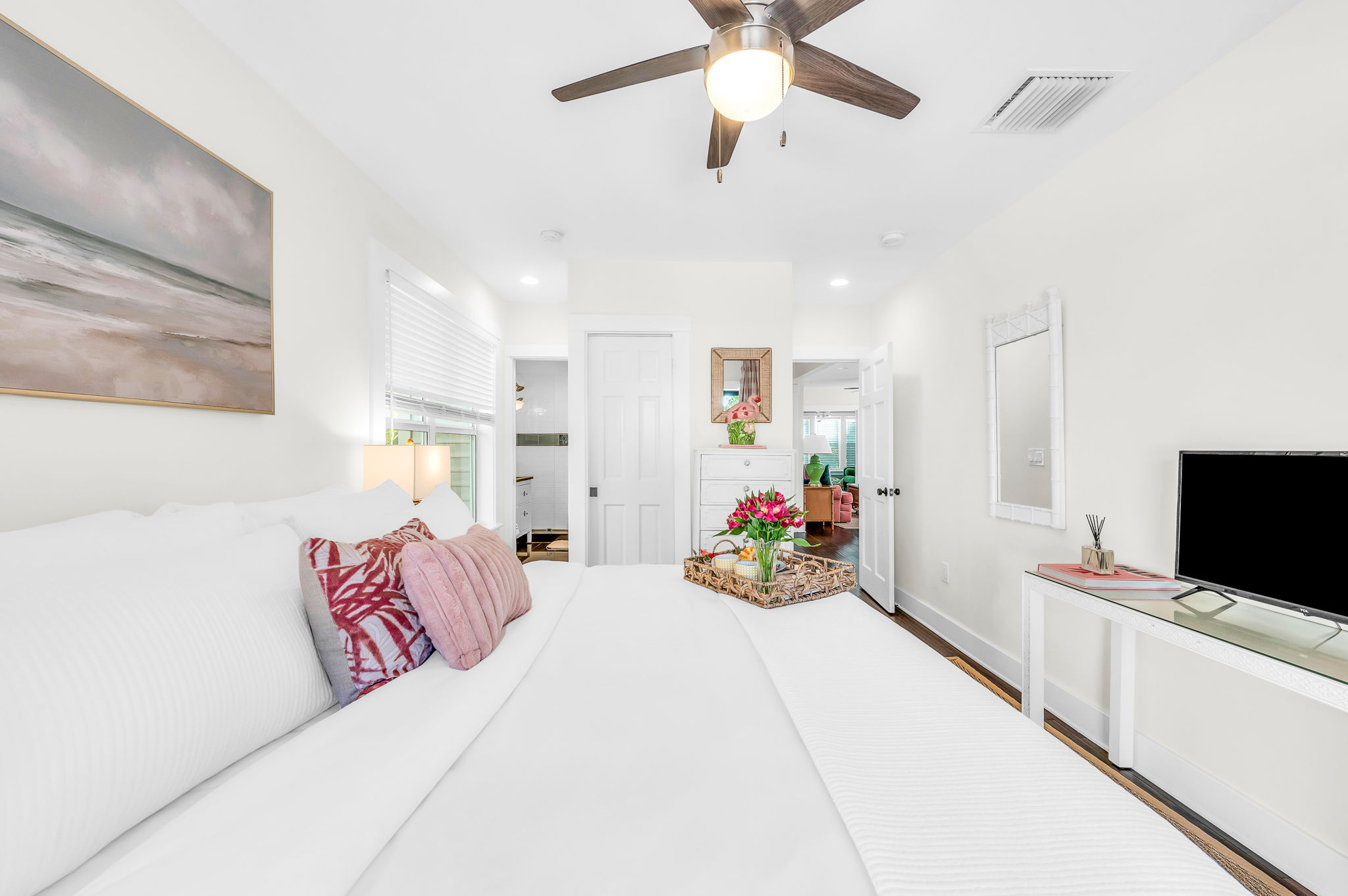 Serene king primary suite featuring a smart TV, private en-suite bathroom, and elegant French doors that open directly to the pool—perfect for seamless indoor-outdoor living and relaxing mornings or evenings.