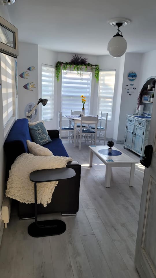 Living area with dining table for 4 guests, futon that folds in a single bed for 1 adult or 2 small children, and app TV.