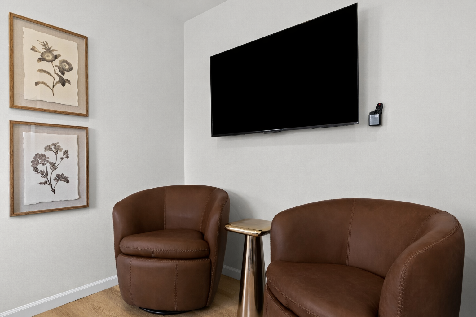 Cozy seating nook with plush chairs and wall-mounted TV—perfect for unwinding, reading, or enjoying a quiet evening in comfort.