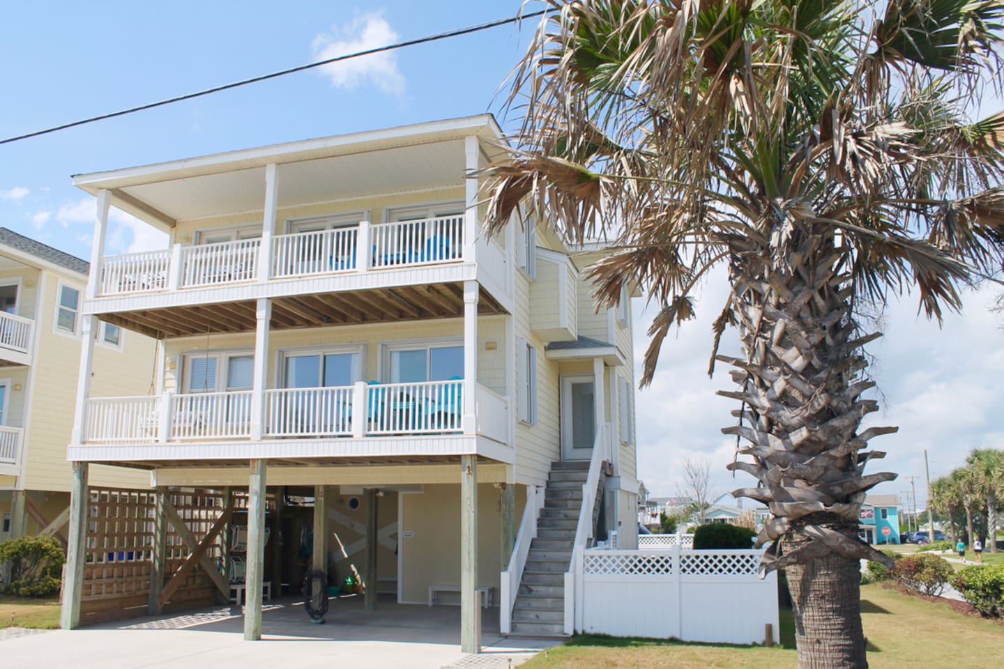 Exterior, front of house. Parking for 6. Entry to outdoor showers on left side of carport. Access to basement bedroom and elevator in carport. 