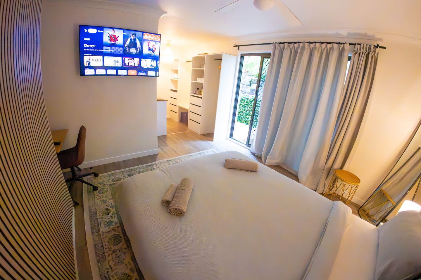 newly added acoustic panelling on the left.  In the distance opposite the kitchen there is a place to hang and store your clothes as well as put away your luggage.