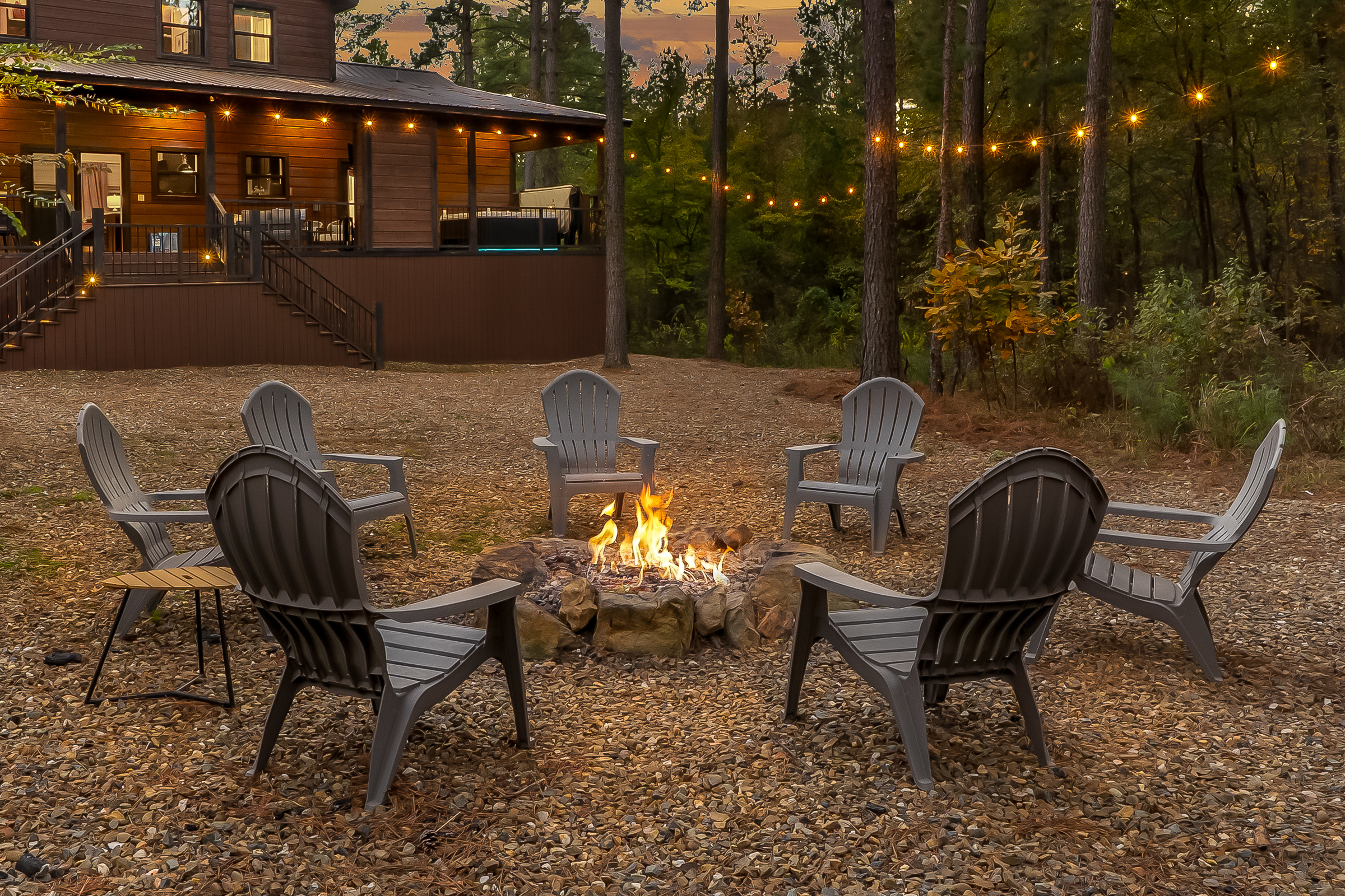 A cozy firepit corner framed by twinkle lights, made for golden hour glow, star filled skies, and long talks that stretch late into the night.